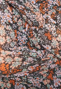 Tissu fluide avec un petit motif floral dans des tons orange atténués, noir, vert clair et blanc, présentant des détails froncés et plissés.