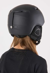 Zwart skibril met een matte afwerking, ventilatiegaten en verstelbare riemen. Voorzien van een nauwsluitend ontwerp en gevoerde oorkappen.