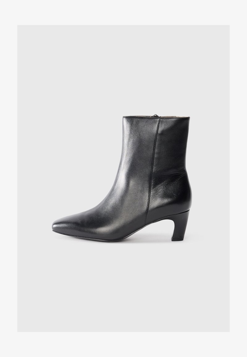 Bota de tornozelo em couro preto com bico fino e salto baixo. Textura suave, fecho com zíper nas costas. Design elegante.