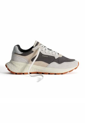 Zapatilla de running ligera con una parte superior de gamuza gris y beige, acentos negros, cordones blancos y una entresuela blanca texturizada con una suela naranja.
