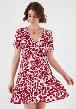 Rot-weiß gemustertes Wickelkleid mit kurzen Ärmeln, V-Ausschnitt und tailliertem Schnitt, das einen ausgestellten Rock und strukturierten Stoff aufweist.