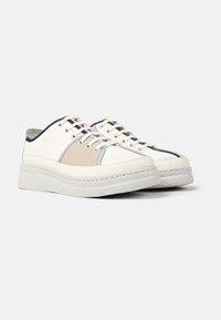 Weiße Sneakers mit einer dicken Sohle, die mehrfarbige Einsätze in Beige, Hellblau und Rosa aufweisen. Akzentuiert mit kontrastierenden Schnürsenkeln und Nähte.
