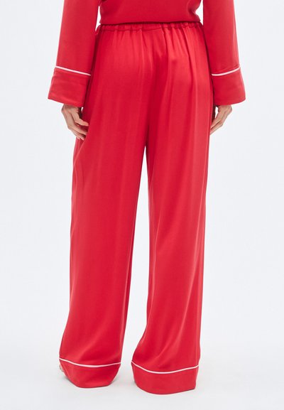 Κόκκινο σατέν παντελόνι με φαρδιά γραμμή και ελαστική μέση. Διαθέτει λευκή διακοσμητική τρέσα στα τελειώματα, λεία υφή και άνετη εφαρμογή.