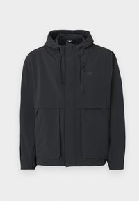 Μαύρο ελαφρύ μπουφάν με κουκούλα, εμπρόσθιο φερμουάρ, τσέπη με φερμουάρ στο στήθος, δύο μεγάλες εμπρόσθιες τσέπες με καπάκι και ρυθμιζόμενη κουκούλα με κορδόνι.