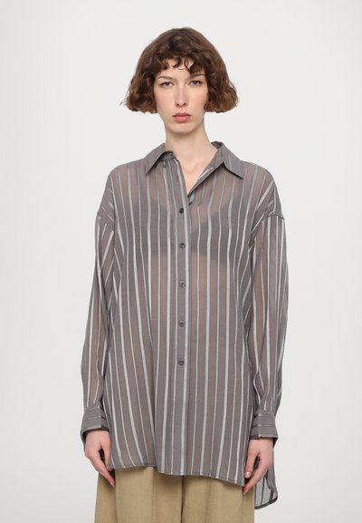 Chemise légère grise à boutons avec des rayures verticales blanches, manches longues et col classique, présentant une coupe décontractée et une texture douce.