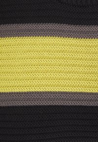 Strikket tekstil med vandrette striber i gul, grå og sort. Teksturen er kraftig med et garnlignende udseende, der fremhæver kontrasten.