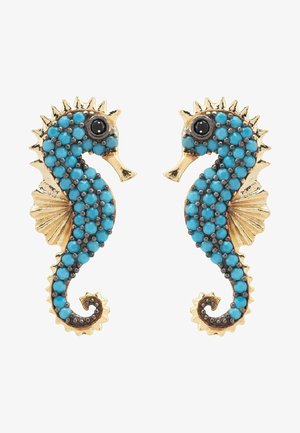 Pendientes en forma de caballito de mar en tono dorado adornados con cuentas de turquesa y acentos en negro, que presentan aletas detalladas y colas rizadas para un aspecto texturizado.