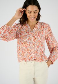 Bloemige blouse in tonen van oranje en blauw, met een knoopsluiting aan de voorkant, pofmouwen en een lichtgewicht stof met een gestructureerd patroon.