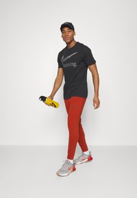 Nike Performance TAPER - Træningsbukser - rugged orange black