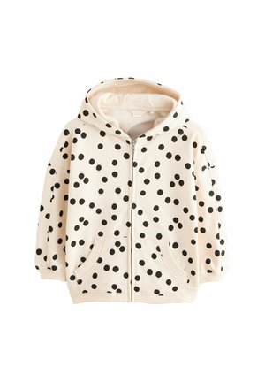 Cream-colored children's zip-up hoodie with black polka dots, front pockets, ribbed cuffs, and a hood.