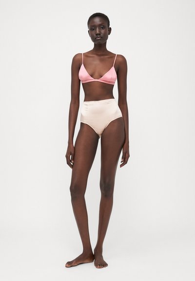 Bralette de satén rosa claro con tirantes finos y braguita de bikini beis de talle alto semitranslúcida, textura suave y diseño minimalista.