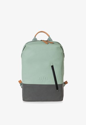 Zaino con un corpo verde menta, fondo grigio, dettagli in pelle e una tasca frontale con zip. Dotato di manico e spallacci regolabili.