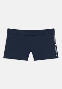 Μαγιό σορτς σε ναυτικό μπλε χρώμα, κατασκευασμένο από μαλακό, ελαστικό ύφασμα με μονόχρωμο σχέδιο. Στην πλευρά είναι τυπωμένο το λευκό λογότυπο "TOMMY HILFIGER".