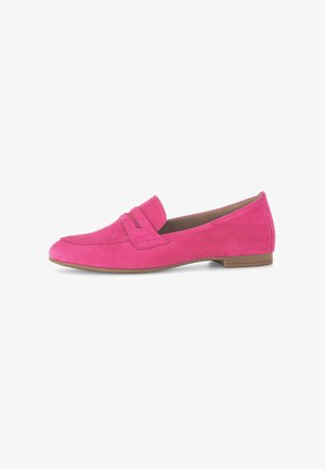 Mocassins en daim rose à bout rond et une bande décorative à l'avant, avec une semelle plate en caoutchouc brun.