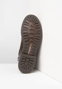 Suela de bota de cuero marrón con surcos profundos, cremallera lateral, talla 42, y marca "NeroGiardini Made in Italy".