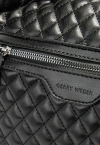 Borsa a tracolla nera trapuntata con finitura in pelle texture. Dotata di una tasca con cerniera e di una placca impressa con "GERRY WEBER."