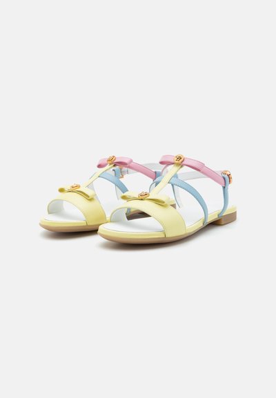 Sandalias de cuero amarillas y azules con acentos rosas, detalle de lazo, punta abierta, tacón plano y herrajes en tono dorado.