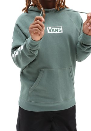 Sweat-shirt vert avec une poche kangourou à l'avant, logo Vans blanc et motif damier blanc sur les manches. Cordons de capuche réglables inclus.