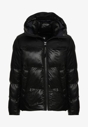 Zwarte pufferjack met een capuchon, voorzien van een mix van glanzende en matte texturen, een voorrits en twee zijzakken.