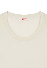 Camiseta beige de manga corta con cuello redondo. Cuenta con una etiqueta "JOTT" en rojo en el cuello. Tejido suave y texturizado.