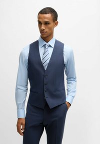 Blue plaid vest over a light blue dress shirt, featuring a tailored fit, five buttons, and two side pockets; paired with a striped tie.