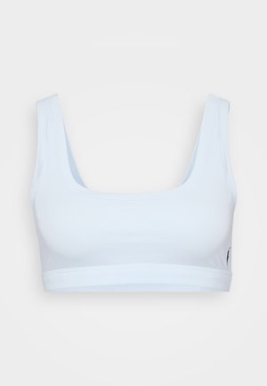 Light blue sports bra made of soft fabric, featuring a square neckline and wide straps. No visible hardware or embellishments.