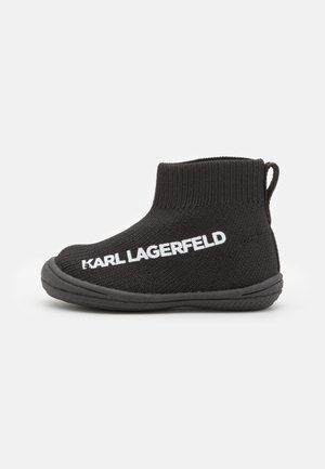 Chaussure chaussette en maille noire à la cheville avec une semelle épaisse et un logo blanc Karl Lagerfeld sur le côté, avec une languette à l'arrière.