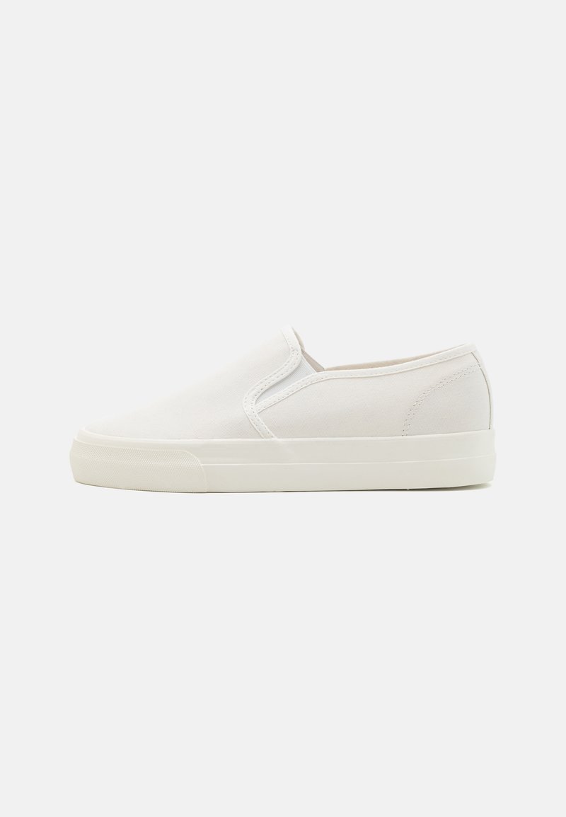 Witte canvas instap-schoen met een vlakke rubberen zool, ronde neus en elastische zijkanten. Minimalistisch ontwerp met een gladde textuur.