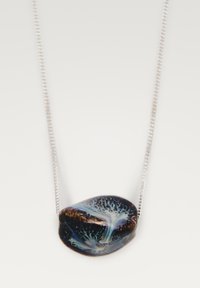Glas hangpendant met een gladde, ronde vorm met donkere blauwe, zwarte en iriserende patronen, aan een dunne zilveren ketting.