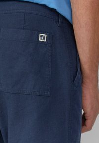 Marineblauwe linnen shorts met een achterzak en een klein, lichtgekleurde logopatch. Gladde textuur en recht afgesneden ontwerp.