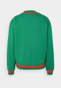 Sweat-shirt vert à manches longues avec poignets, col et ceinture côtelés rouges, montré de dos sur un fond blanc uni.