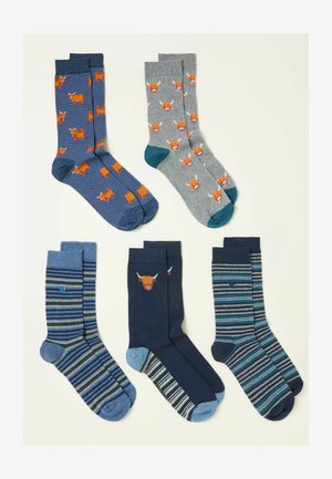 Pięć par męskich skarpet z różnymi wzorami: szkockie krowy, paski oraz jednolite kolory w odcieniach niebieskiego, szarego i morsko-zielonego, z kontrastowymi wzmocnieniami na palcach.