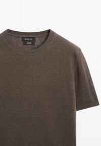 Braunes kurzärmeliges Leinen-Strick-T-Shirt mit Rundhalsausschnitt und Massimo Dutti Etikett auf weißem Hintergrund.