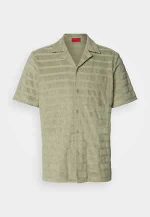 Short-sleeve shirt in light green, textured fabric with alternating horizontal stripes, button closure, and a chest pocket with logo detail.