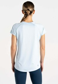 Camiseta deportiva de color azul claro con mangas cortas, confeccionada con tejido que absorbe la humedad, que presenta un dobladillo curvado y un sutil logo en la parte inferior.