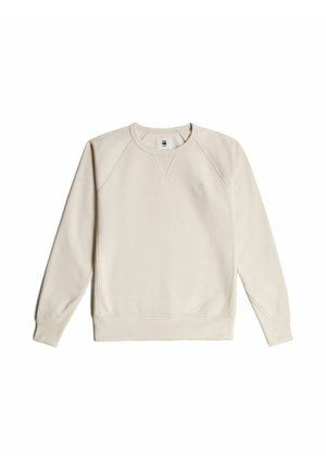 Light beige sweatshirt made of soft fabric, featuring a crew neck, raglan sleeves, and a small logo on the chest. Smooth texture.