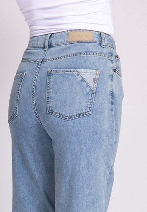 Light blue denim jeans with a high waist, showing two back pockets and a leather logo patch on the waistband. Smooth texture, relaxed fit.