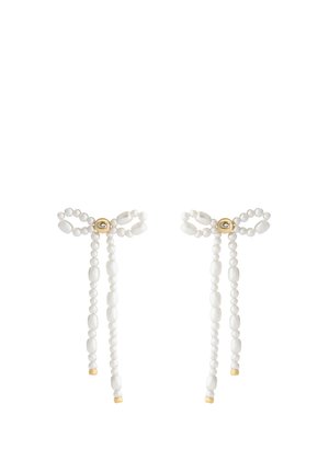 Boucles d'oreilles fines en perles blanches en forme de nœuds avec des accents dorés et une petite perle ronde dorée au centre de chaque nœud.