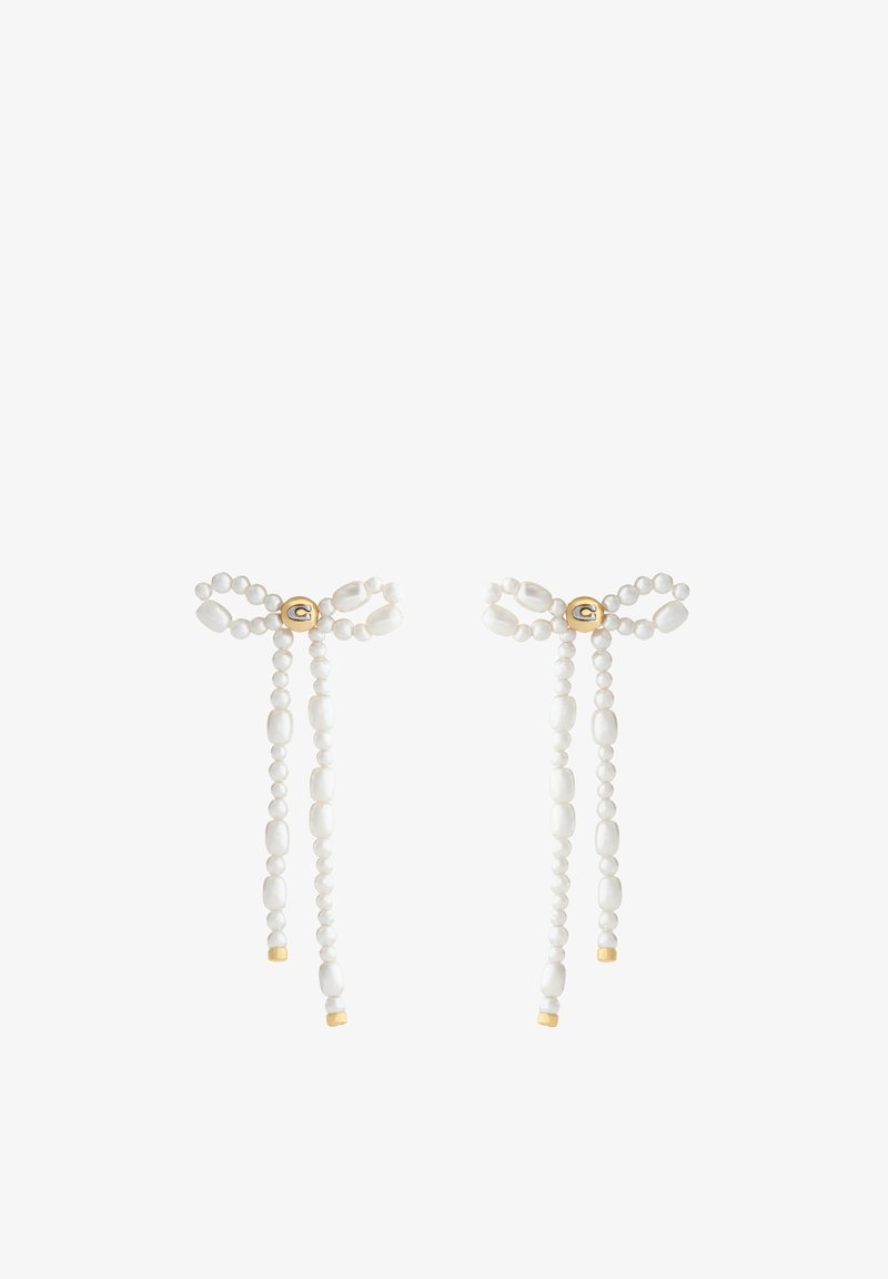 Boucles d'oreilles fines en perles blanches en forme de nœuds avec des accents dorés et une petite perle ronde dorée au centre de chaque nœud.