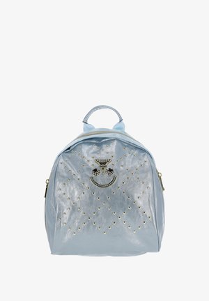 Rucsac metalic albastru cu formă rotunjită, accente cu ținte, un motiv cu față zâmbitoare și un mâner superior. Are închidere cu fermoar.