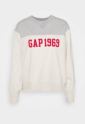 Bluza typu crewneck z szarym karczkiem i kremowym tułowiem, z wyraźnym czerwonym napisem "GAP 1969" na piersi oraz ściągaczami przy mankietach.
