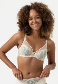 Lace bh met zachte pastelgroene en koraalkleurige bloemstickers, beige onderlaag, dunne verstelbare bandjes en een strikaccent in het midden.