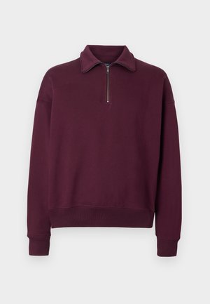 Burgundijas krāsas sporta krekls ar rāvējslēdzēja apkakli, garām piedurknēm, ribota malas un mīksta tekstūra. Ikdienišķs dizains, kas ideāli piemērots slāņošanai.