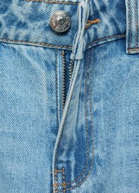 Ljusblå denimjeans med dragkedja och knappstängning. Tyget har en mjuk textur med subtila blekningar och kontrasterande sömmar.