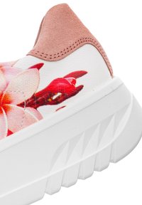Bílá teniska s hrubou texturovanou podrážkou, růžovou semišovou patkou a velkým růžovo-červeným květinovým motivem na bočním panelu.