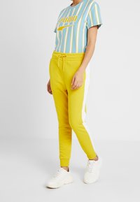 Puma Pantalones deportivos - mustard yellow