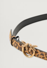 Leopárdmintás velúr öv fekete bőr háttérrel, arany színű, kerek csattal, amelyen két madár díszítés található. A márkanev látható.