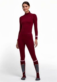 Dunkelrotes Thermo-Baselayer-Set mit langärmeligem Oberteil und enganliegenden Hosen. Mit grauen Akzenten an den Beinen und Rippenstruktur. Design mit hohem Kragen.