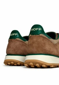 Sneaker in suede marrone con accenti in pelle verde, suola intermedia bianca e suola in gomma testurizzata. Presenta il marchio "HOFF" sul tallone.