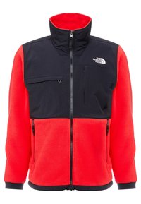 Giacca in fleece rossa e blu navy con colletto alto, chiusura con zip, tasca sul petto e due tasche laterali con zip. Presenta il logo The North Face sul petto.